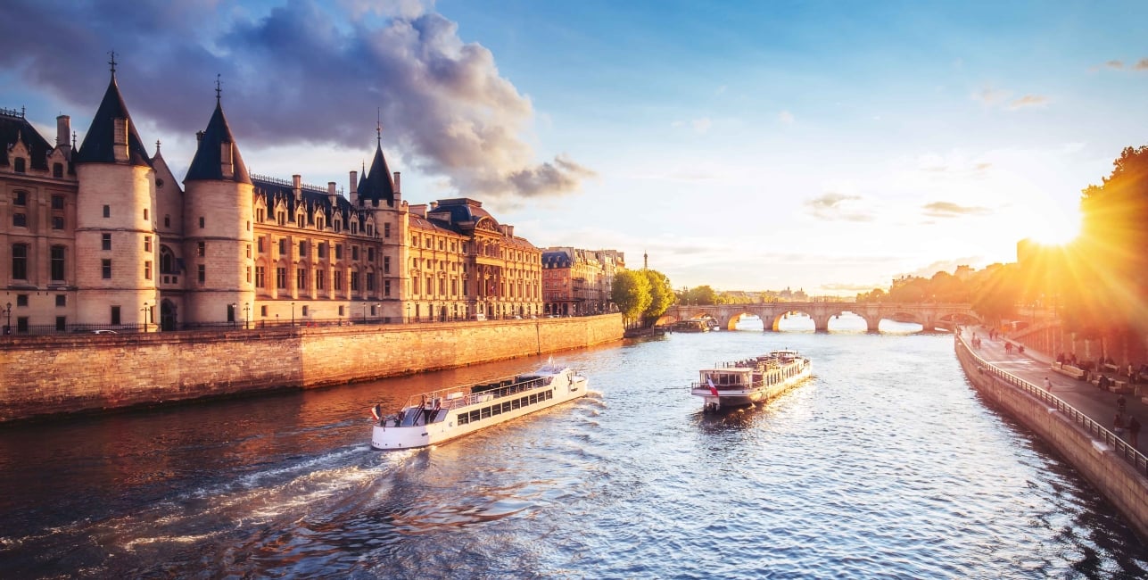 Dramatic sunset over Cite in Paris, France, with Conciergerie, Pont Neuf and river Seine.