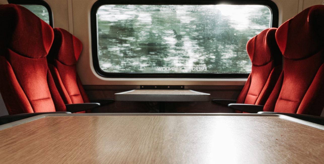 onboard the train looking out window with red seats