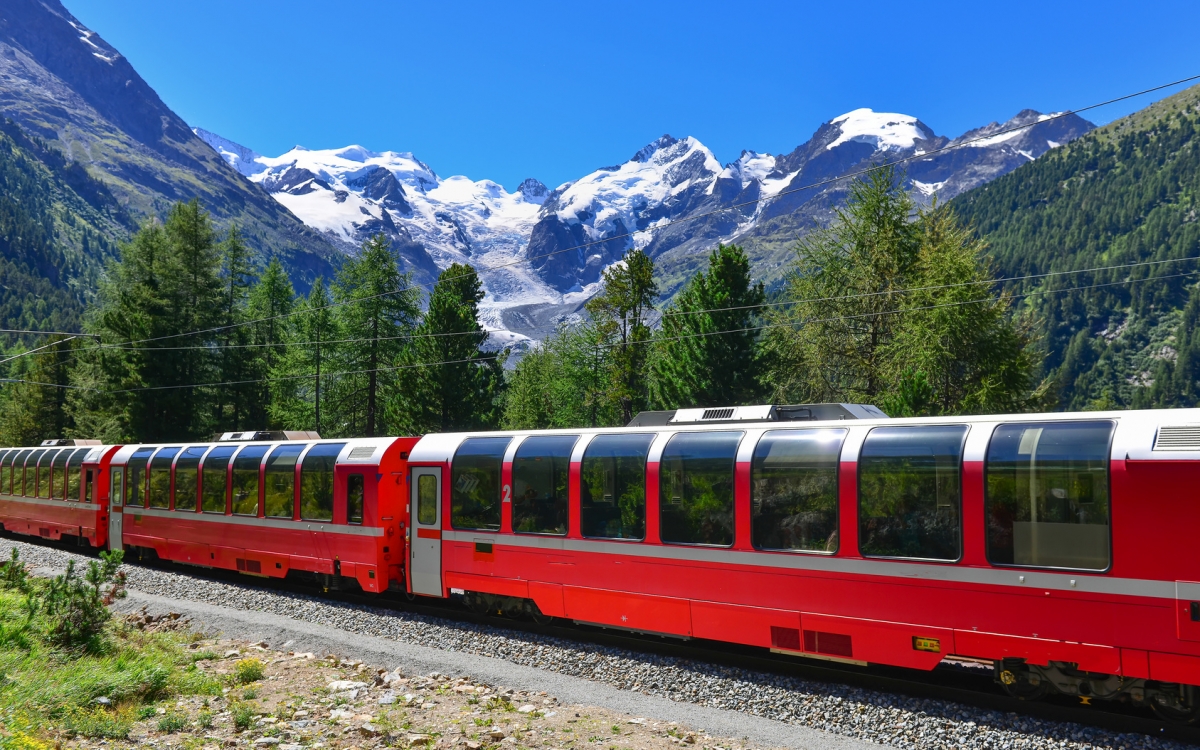 The Bernina Express A train travels through Alpine scenery with bright blue sky