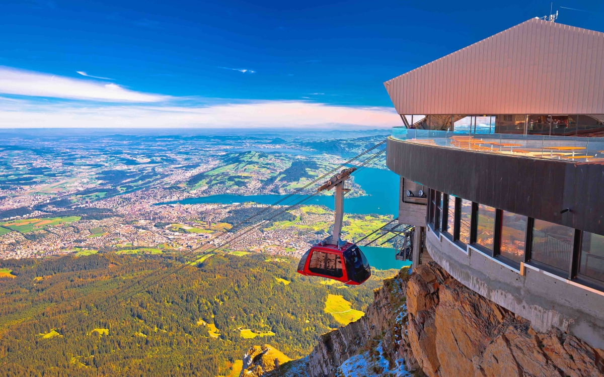 A Gondola approaches the terminal with mountain views in background