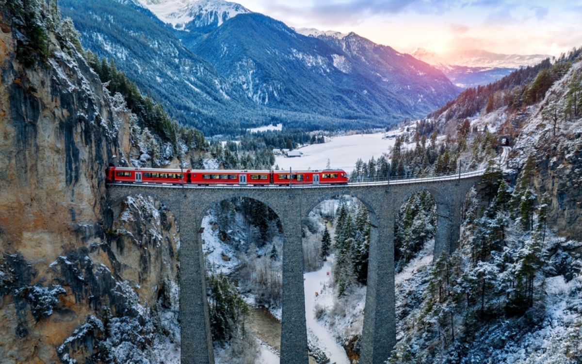Aerial view of Train passing through famous mountain in Filisur, Switzerland train express in Swiss Alps snow winter scenery.