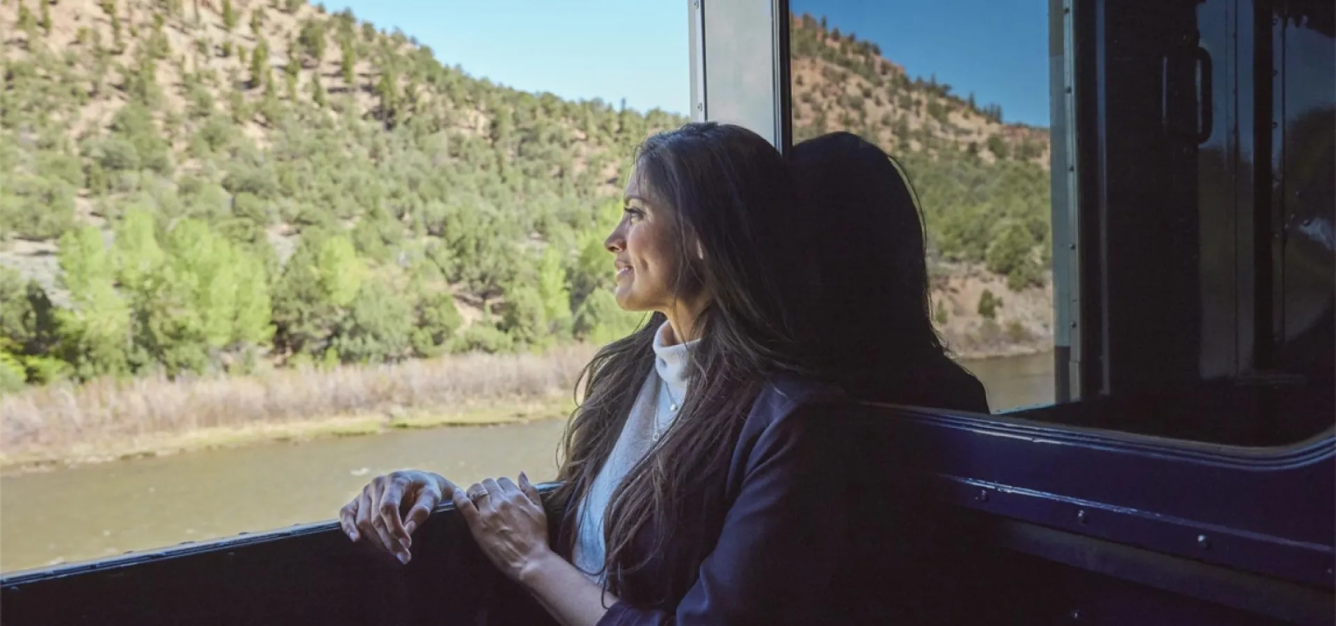 Rocky Mountaineer's Canyon Spirit Train woman looking out the windowonboard