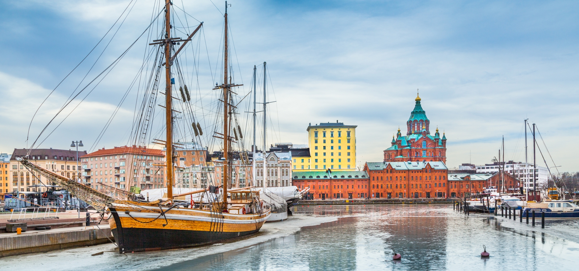 Beautiful view of Helsinki city center with famous Uspenski eastern orthodox cathedral church and old port in Katajanokka district of Helsinki on a cold winter day with blue sky and clouds, Finland