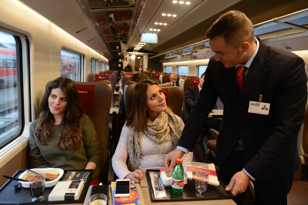 Travellers are served a meal onboard a train