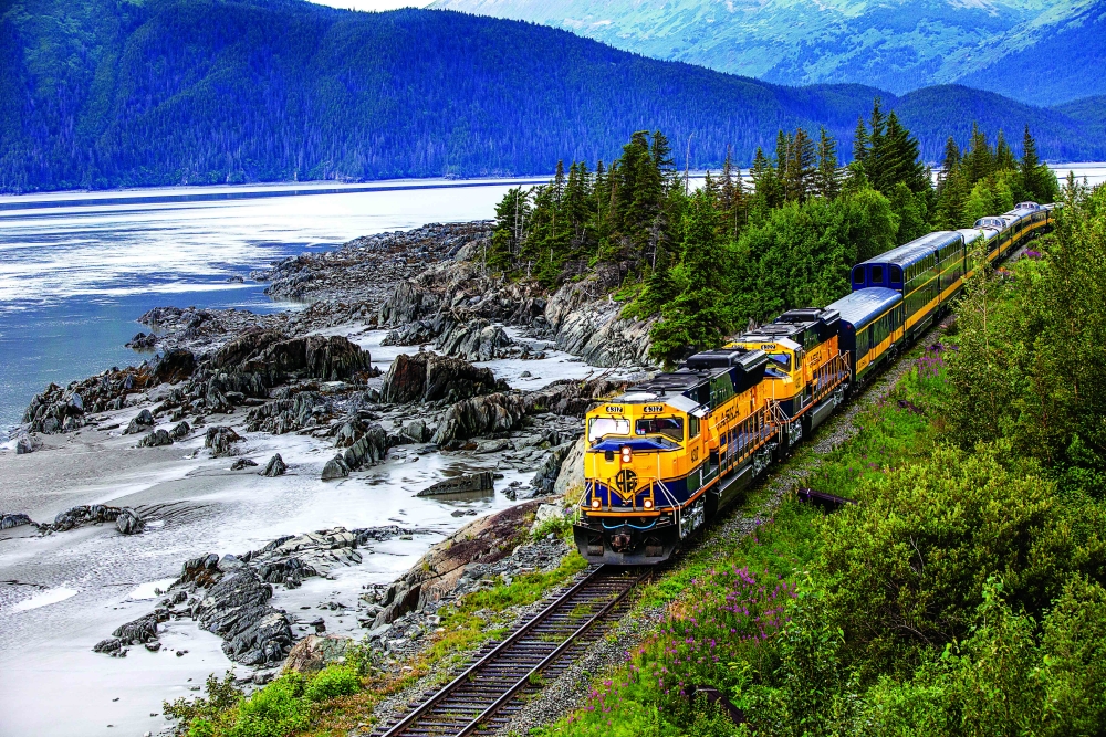 alaska railroad train next to a lake