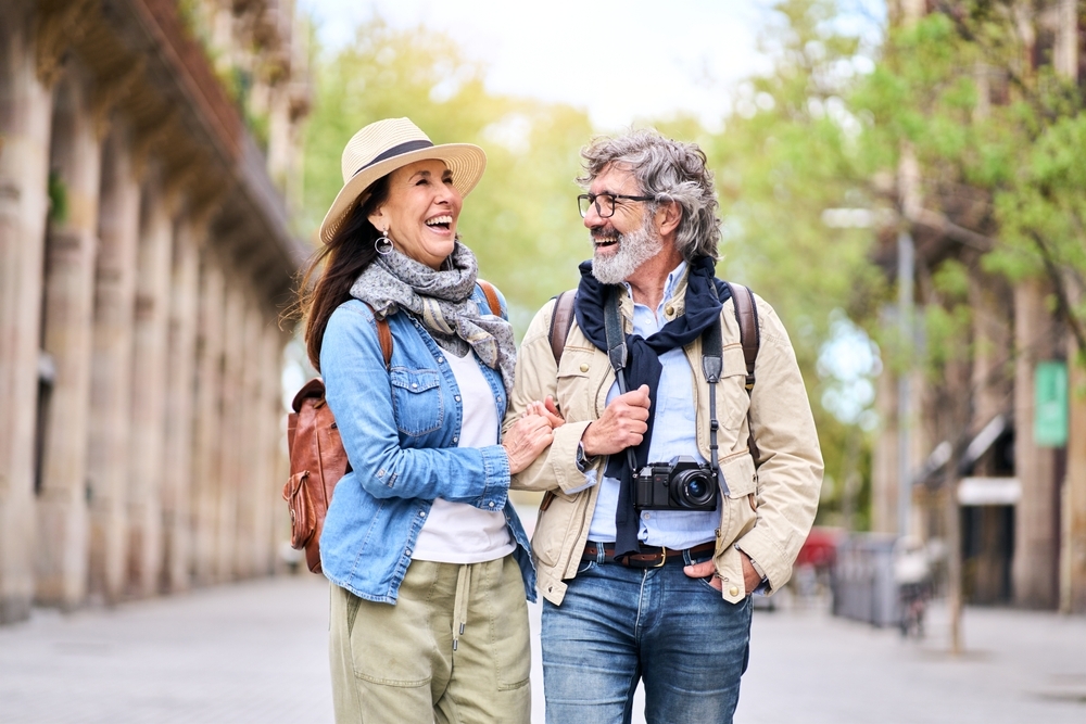 Happy older couple having fun walking outdoors in city.