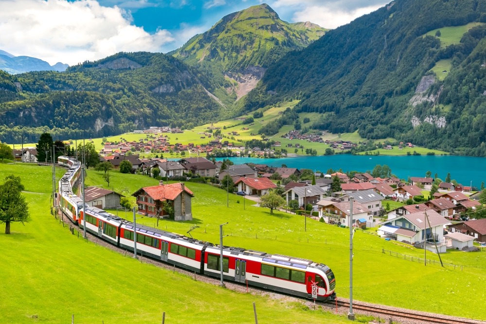 Swiss National Railways A train travels through a Swiss valley and Lake